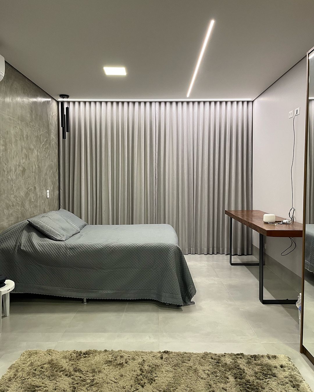 Cortinas cinza em quarto moderno com tapete felpudo