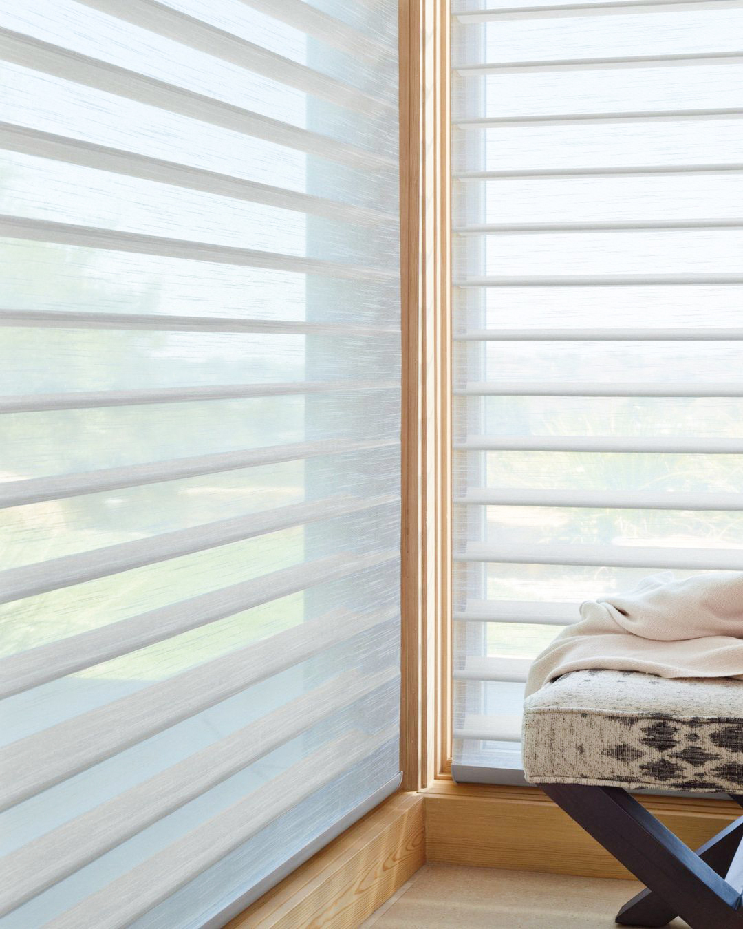 Persiana silhouette branca translúcida em janela de canto com moldura de madeira