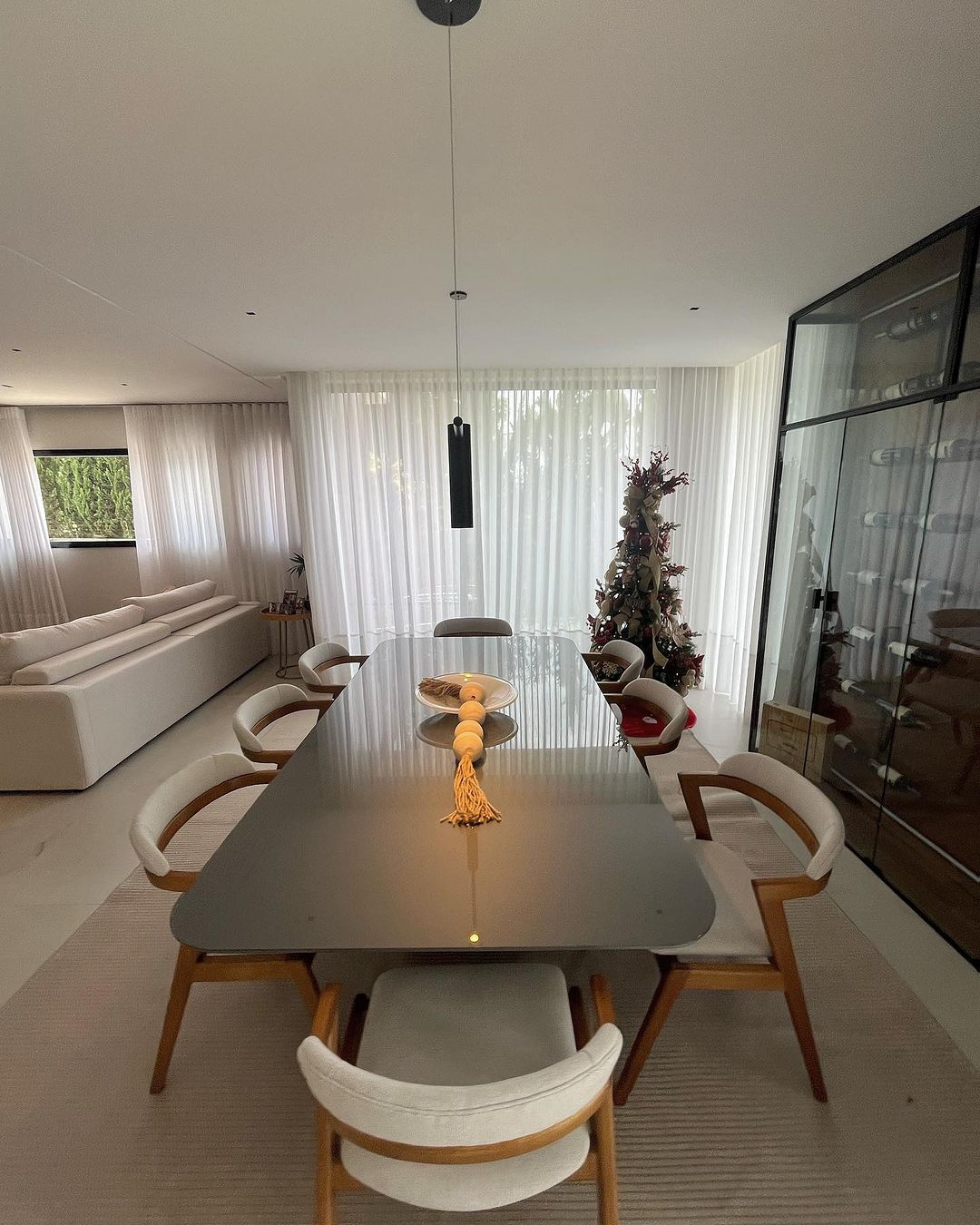 Cortinas brancas em sala de jantar com lustres pretos