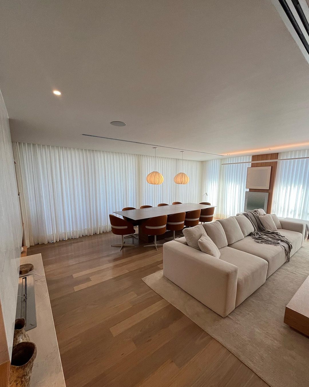 Cortinas brancas em sala ampla com mesa de jantar