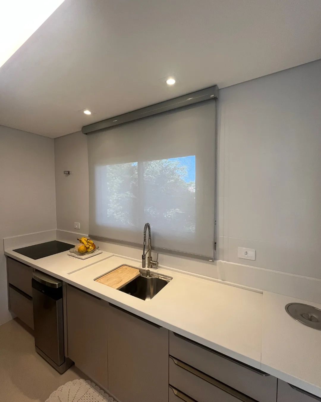 Persiana rolô cinza em cozinha moderna sobre pia e bancada