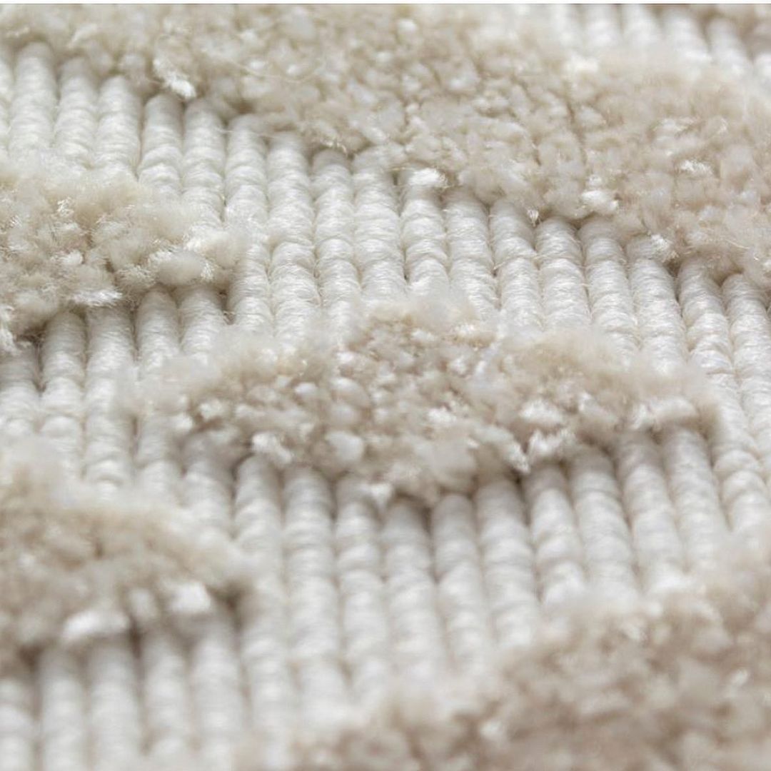 Detalhe de tapete creme texturizado com trama orgânica