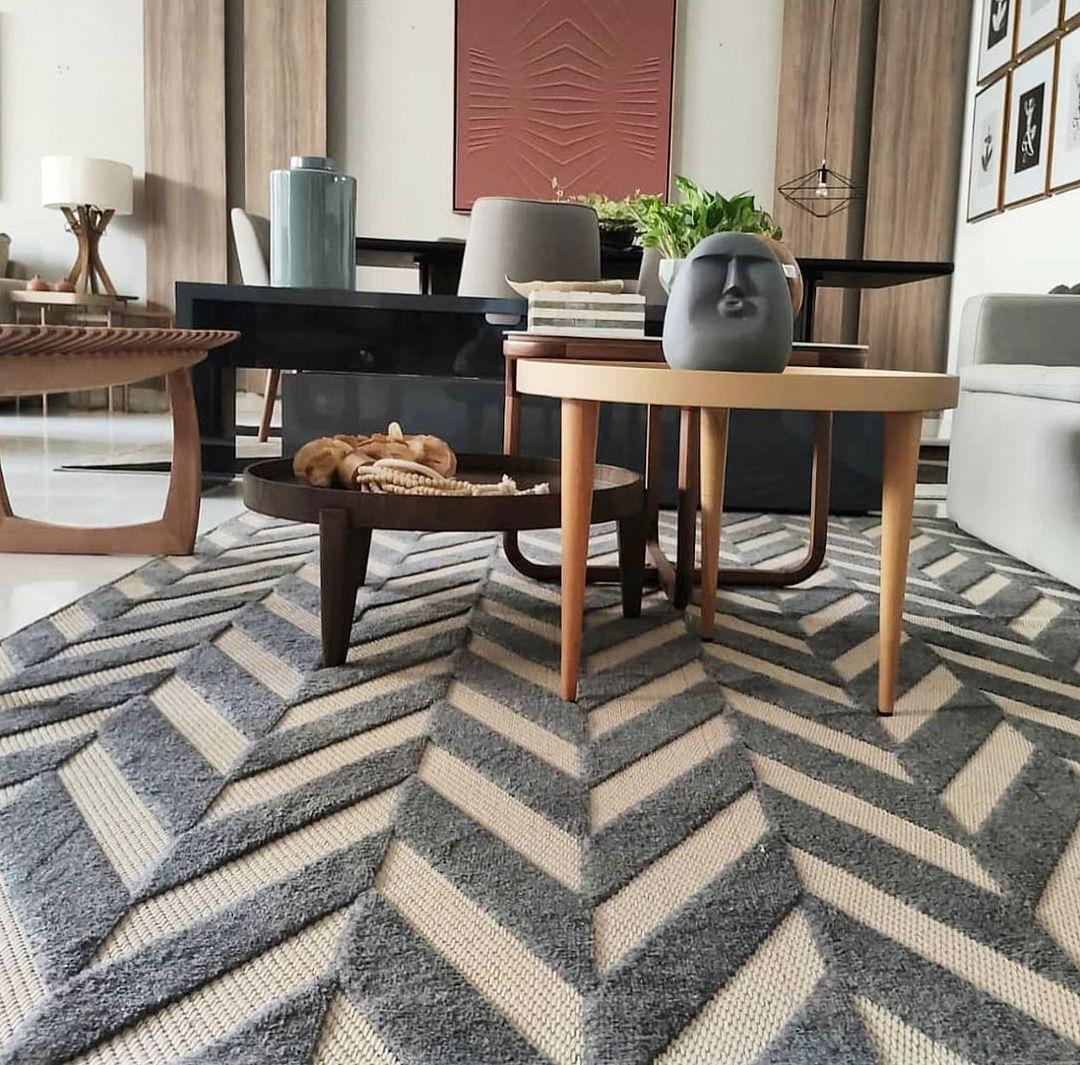 Tapete chevron em cinza e bege com mesas de centro aninhadas