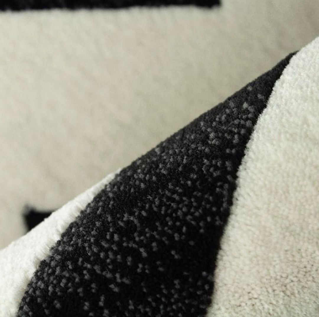 Detalhe de tapete preto e branco com textura geométrica