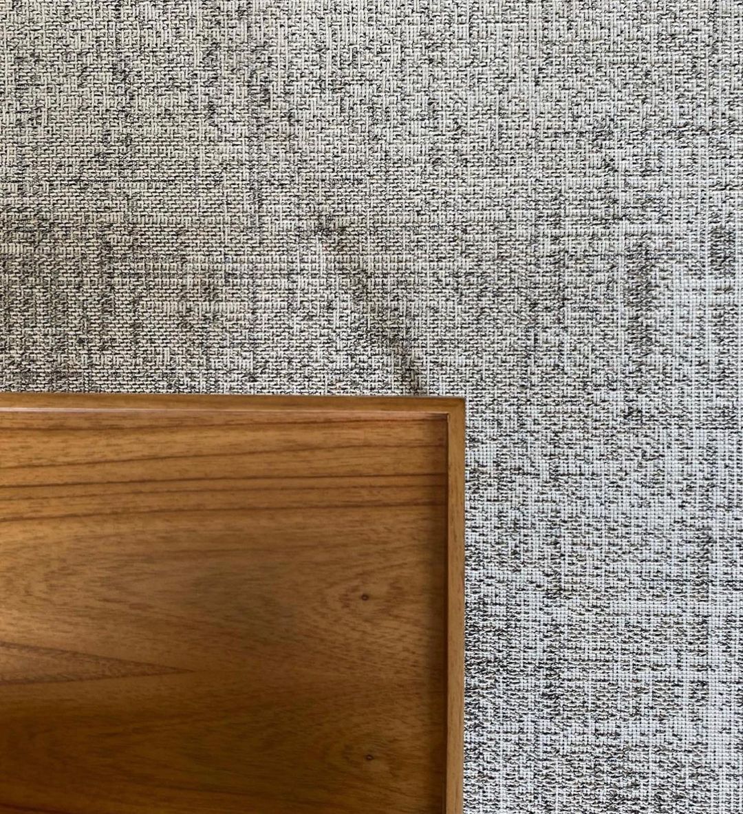 Tapete cinza texturizado com detalhe de móvel de madeira