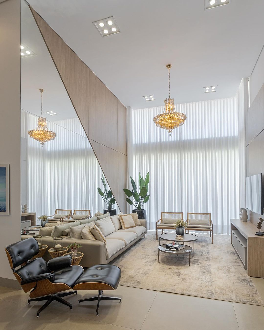 Cortinas brancas em pé direito duplo com lustre