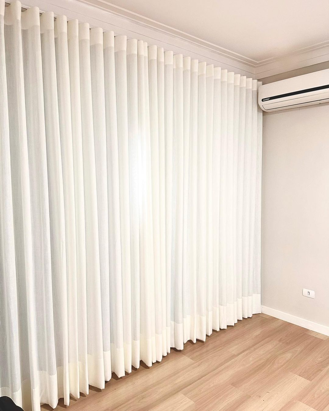 Cortinas brancas verticais em quarto