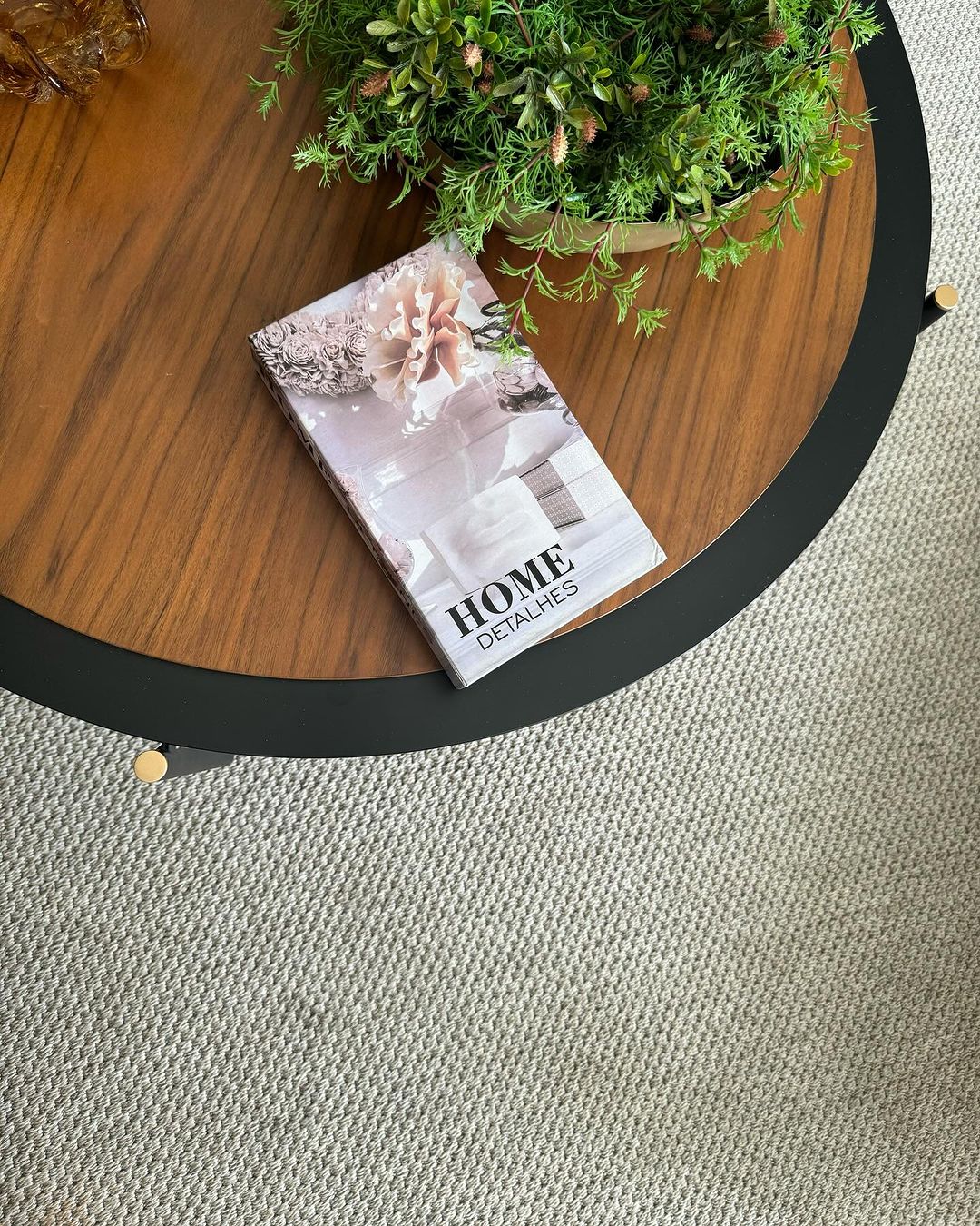 Tapete texturizado bege com mesa de centro redonda de madeira