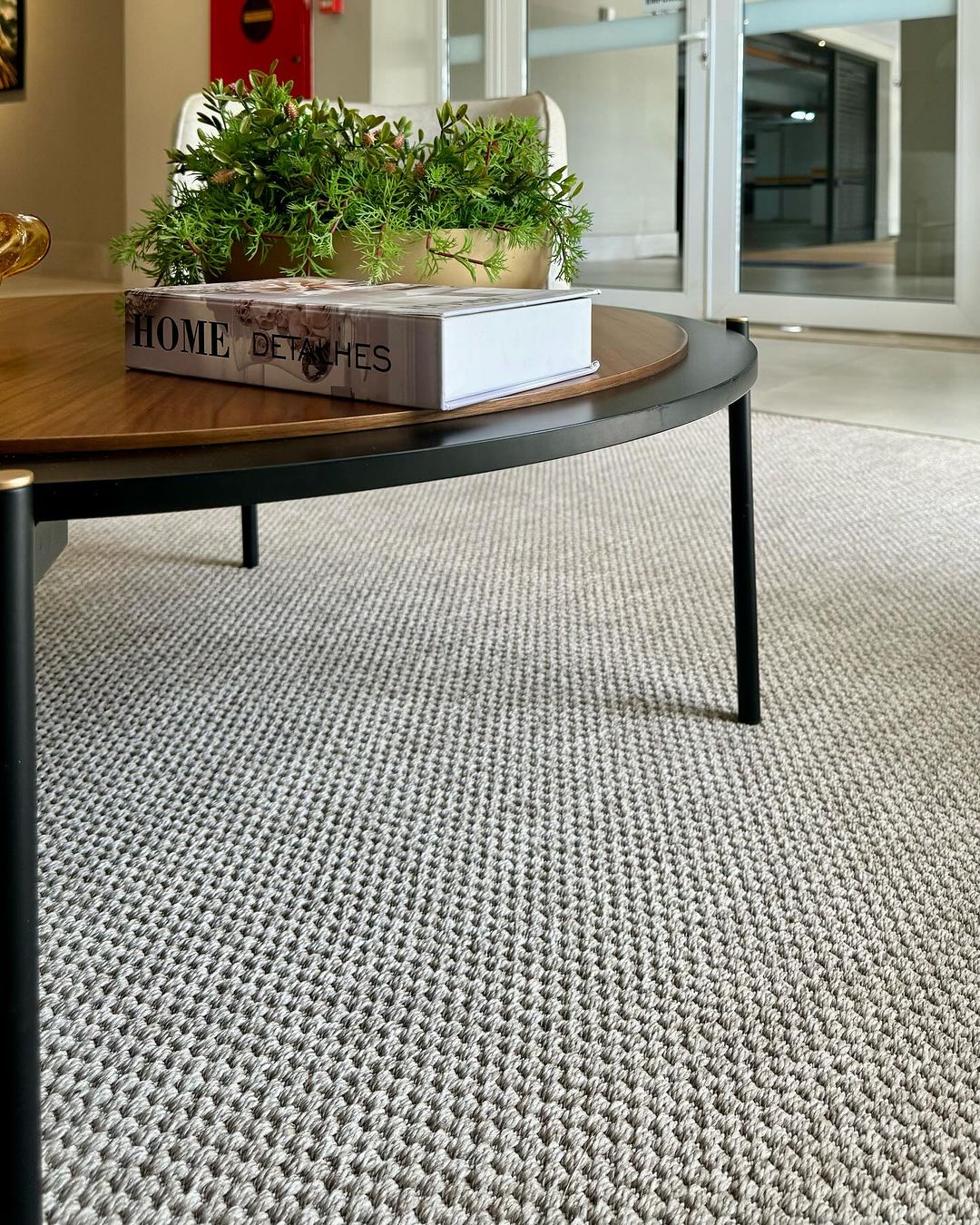 Tapete cinza trançado com mesa de centro redonda