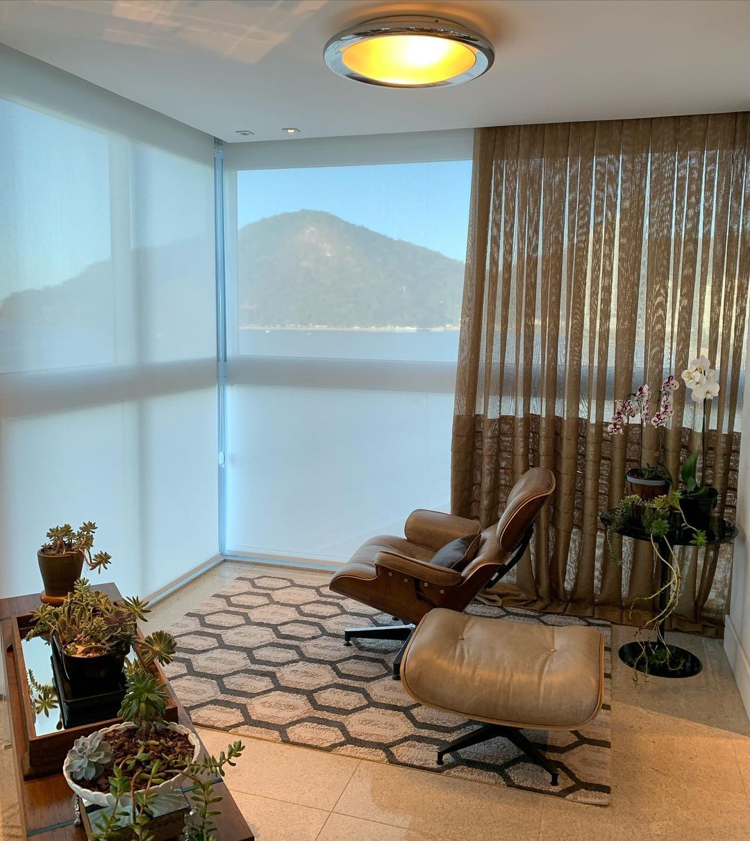 Persiana rolô com cortina em sala de estar com vista para o mar