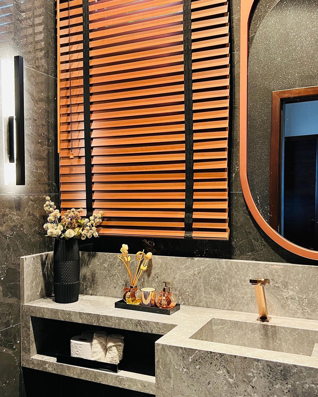 Persianas de madeira em lavabo elegante com acabamento dourado