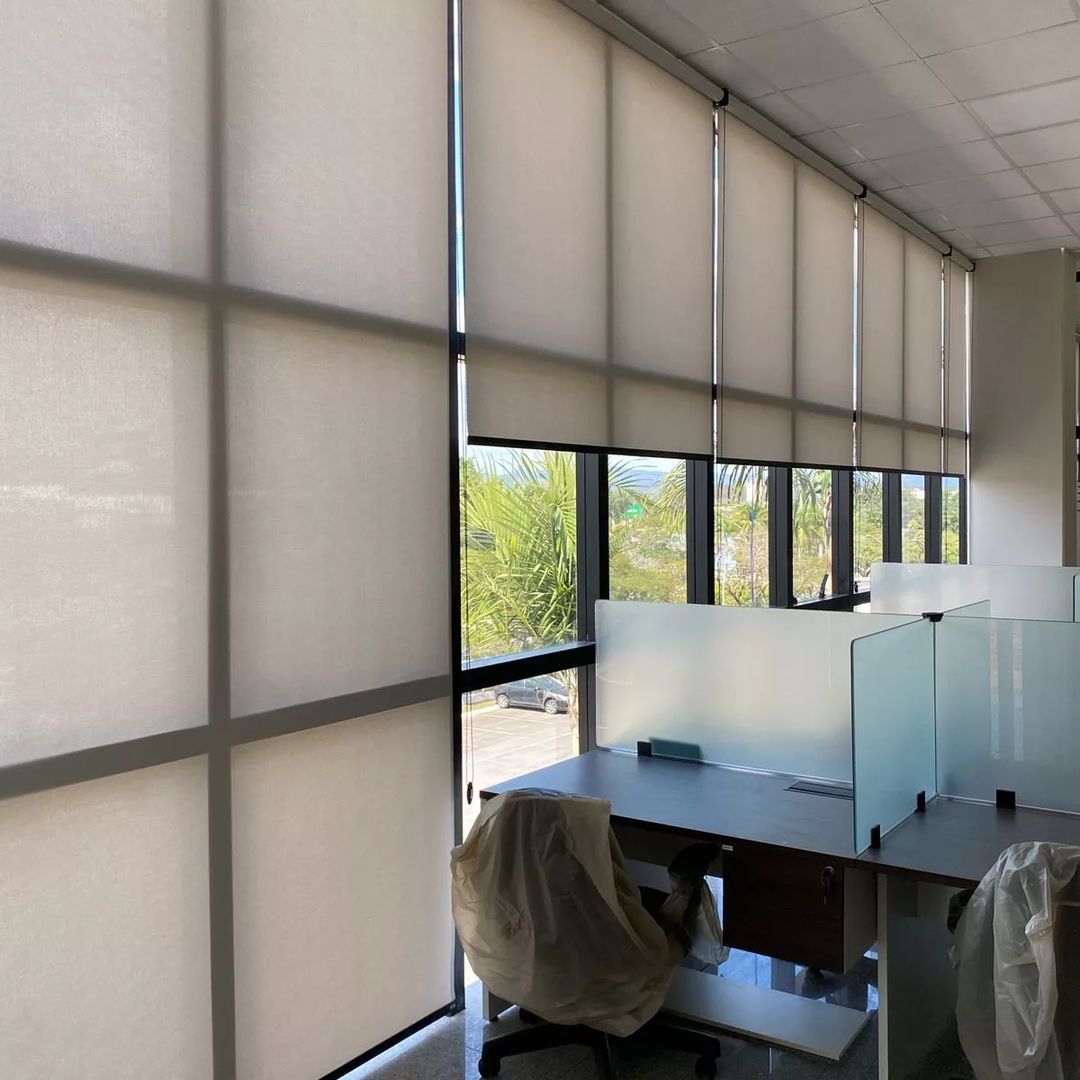 Escritório executivo com persianas rolô tela solar e mesa em L