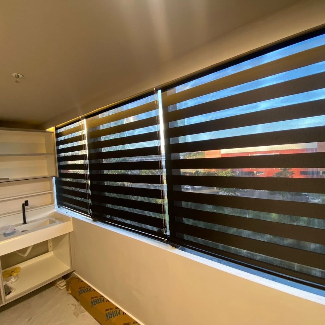 Espaço de spa relaxante com persiana rolô branca e vista urbana panorâmica