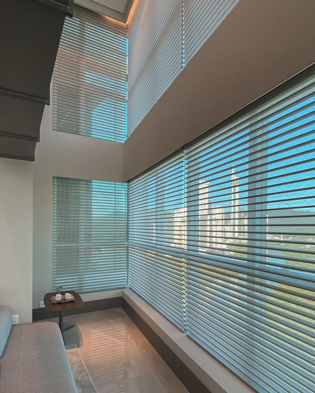 Persianas horizontais azuis em sala de estar com pé direito duplo